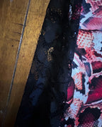 Detail of Venom Flare Remix Pants – One of a Kind Upcycled Statement Piece showcasing colorful snake print and black lace.