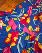 Close-up of the vibrant floral print on the Bloom Riot Maxi Dress, showcasing colorful women's clothing and unique styles.