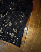 Close-up of celestial-print fabric showcasing gold moons and stars for the Celestial Chaos Two-Piece Set.