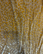 Close-up of the fabric texture of 🛸 Golden Mirage Flare Pants – One of a Kind Upcycled Statement Piece in vibrant patterns.