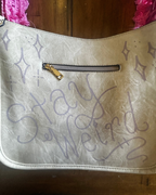 Stay Weird Cow Print Shoulder Bag featuring hand-drawn text and unique design elements, perfect for colorful statement clothing.