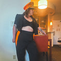Model wearing the Midnight Mischief Upcycled Two-Piece Set featuring pinstripe and vibrant orange elements.