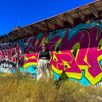 Happy Daze Upcycled Bedsheet Skirt worn against vibrant graffiti backdrop, showcasing funky women's clothing style.