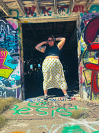 Happy Daze Upcycled Bedsheet Skirt worn by a model in a colorful graffiti backdrop, showcasing unique, handmade women's clothing.