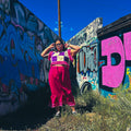 Model showcasing the Hot Mess Express Ruffle Skirt against a colorful graffiti wall, exemplifying funky women's clothing.