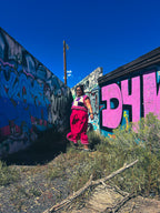 Woman wearing Hot Mess Express Ruffle Skirt, standing in a colorful urban scene with vibrant graffiti.