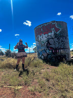Woman posing in the Just Chillin’ Killin’ Upcycled T-Shirt Dress against a colorful graffiti background.