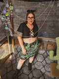Toxic Swirl Handmade Mini Skirt – One of a Kind Upcycled Statement Piece worn by model in a unique setting.