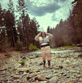 Model wearing the Ultra Remix Hoodie Set – One of a Kind Upcycled Statement Set by a rocky stream, showcasing unique women's clothing.