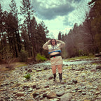 Model wearing the Ultra Remix Hoodie Set – One of a Kind Upcycled Statement Set by a rocky stream, showcasing unique women's clothing.