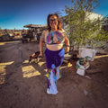 Electric Pulse Bell Bottom Set worn by a smiling woman, showcasing colorful and unique women's clothing in a vibrant outdoor setting.