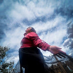 Woman wearing the Betty in Paris Reworked Hoodie Dress, showcasing unique style against a cloudy sky.