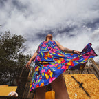 Model wearing Bloom Riot Maxi Dress, a unique and colorful statement clothing piece with floral print and flowy hem.